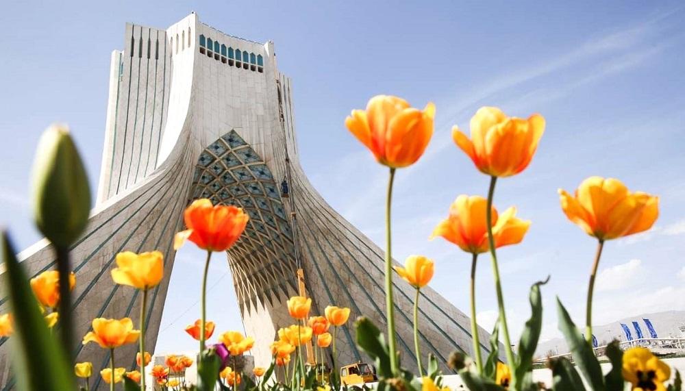 نمایی از برج آزادی از بین گلهای نارنجی