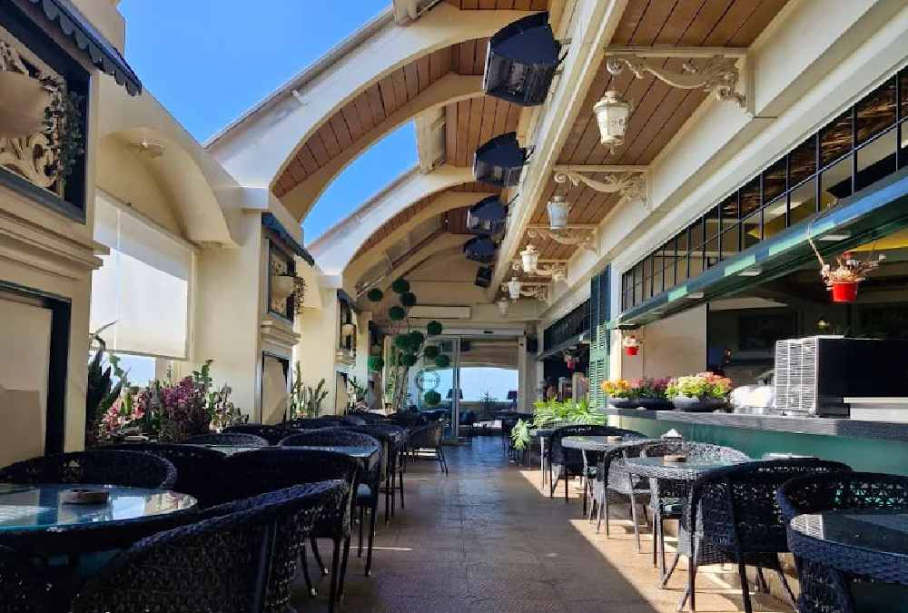 نمایی از فضای باز مسقف شیشهای کافه رستوران آرتیست در روشنایی روز