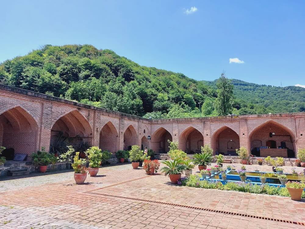 حیاط رستوران کاروانسرای شاه عباسی رشت با حوض آبی در وسط