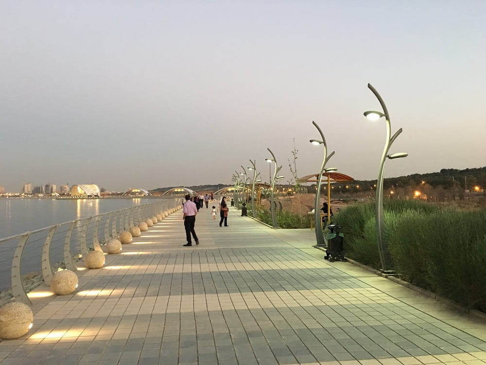 نمایی از پیاده‌روی در پارک چیتگر تهران هنگام غروب