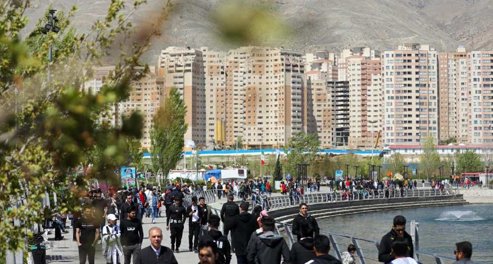 مردم در حال قدم زدن کنار دریاچه چیتگر