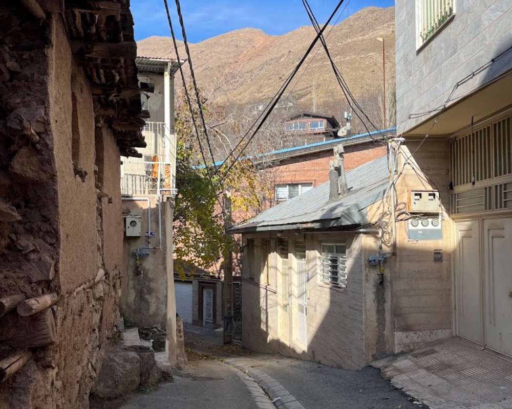 کوچه قدیمی روستای برگ جهان لواسان با بافت سنتی با آسمانی آبی