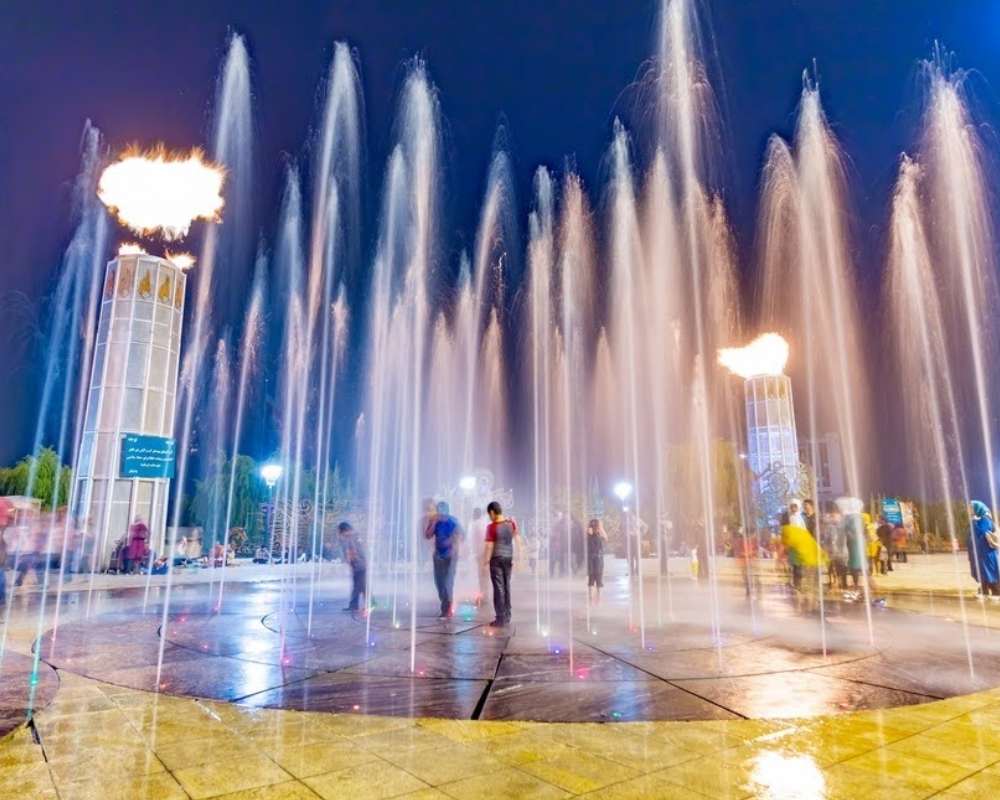 فواره‌های پارک آب و آتش و کودکان در حال بازی بین فواره‌ها