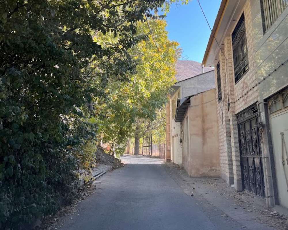 خانه‌های روستای برگ جهان در مقابل درختان پاییزی