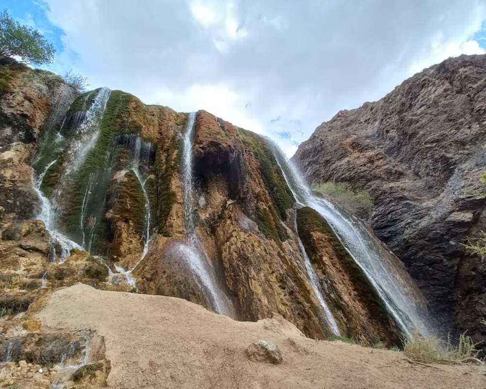 نمایی از آبشار پونه زار با آسمان ابری