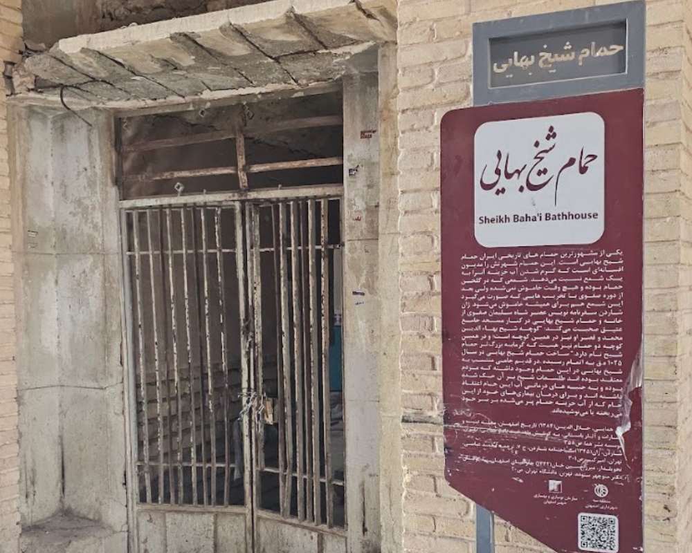 نمایی از یکی از درهای حمام شیخ بهایی و تابلوی توضیحات گردشگری