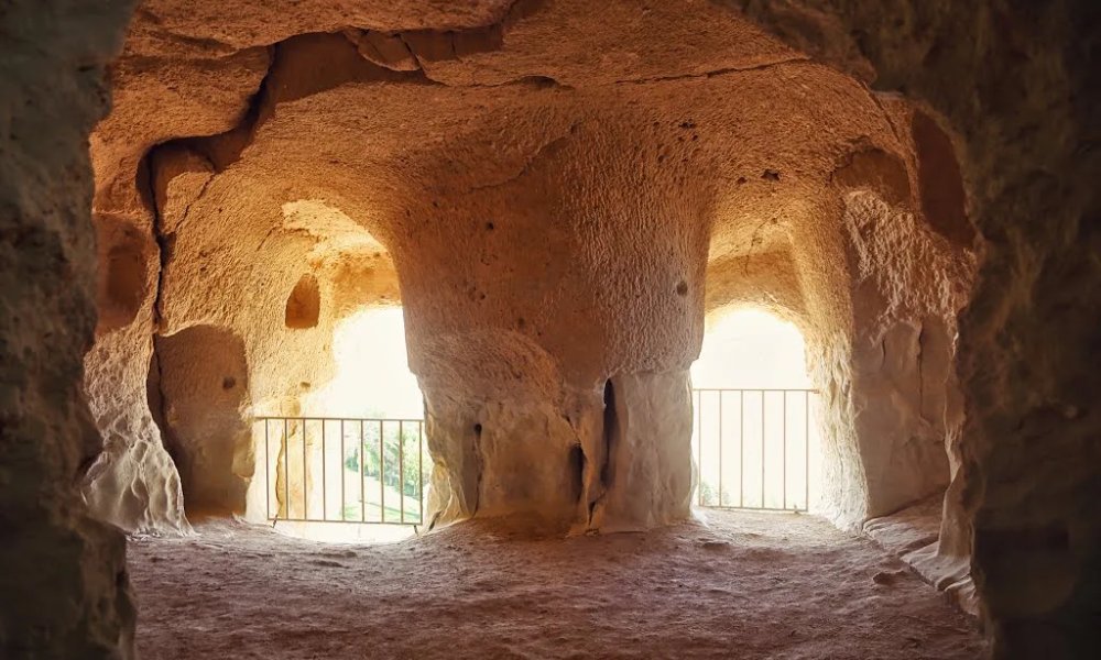 فضای داخلی غار خربس با منظره رو به فضای باز و نرده جلوی آن