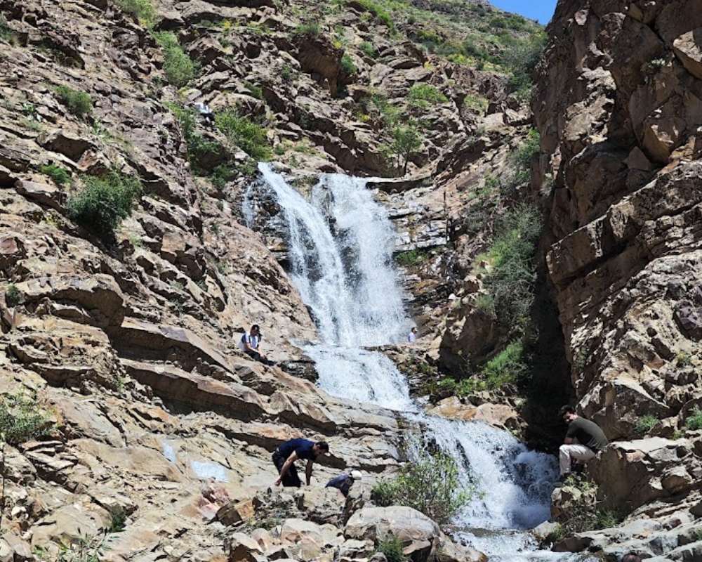 آبشاری زیبا در میان صخره‌هایی با گیاهان کوچک در روستای برگ جهان لواسان