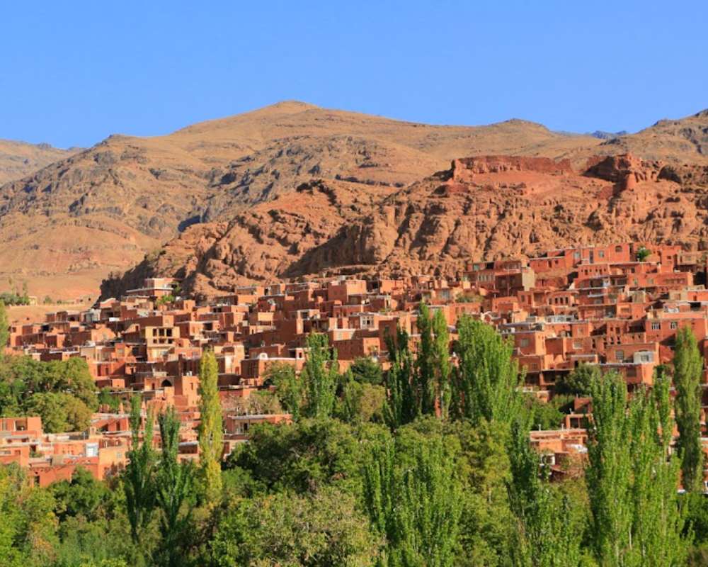 نمایی از خانههای روستای ابیانه در پشت فضای سبز