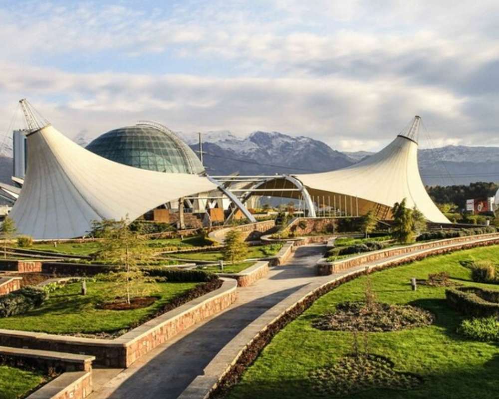 نمایی از فضای سبز داخل پارک با آسمان نیمه ابری