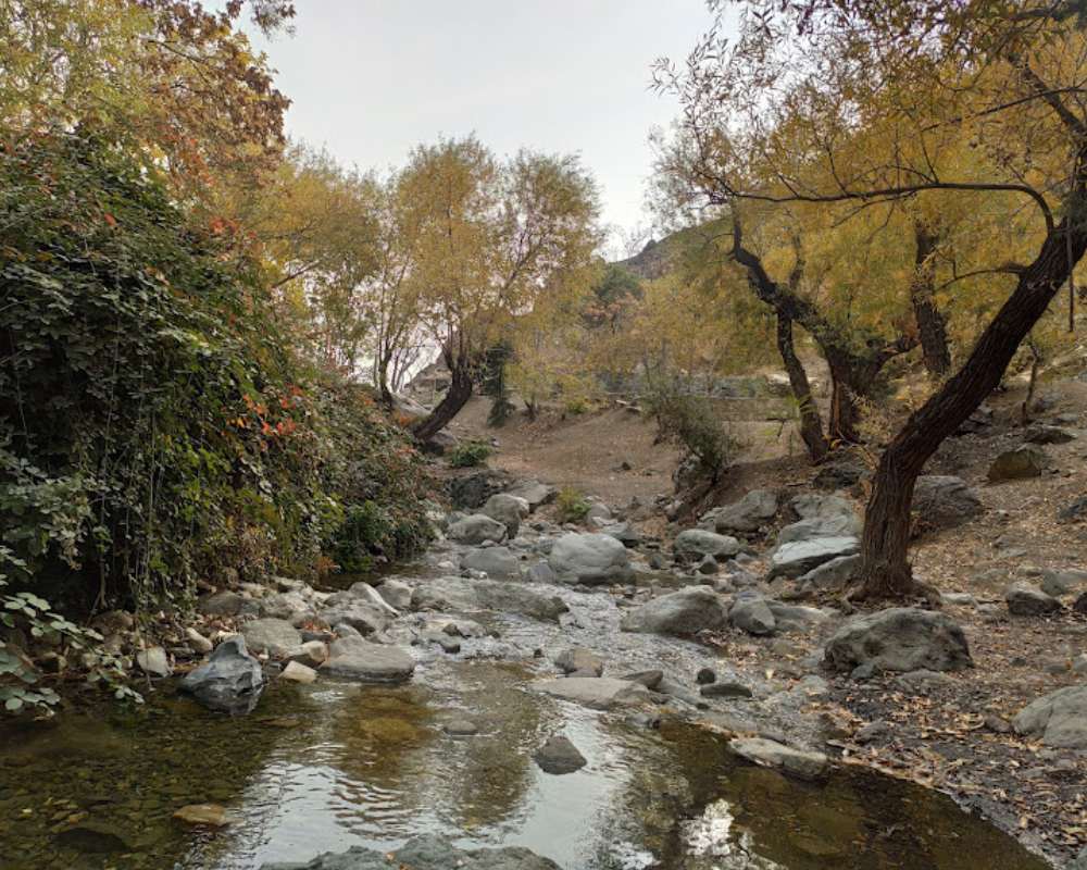 نمای دریاچه و فضای کوهستانی و درختان پاییزی دارآباد تهران