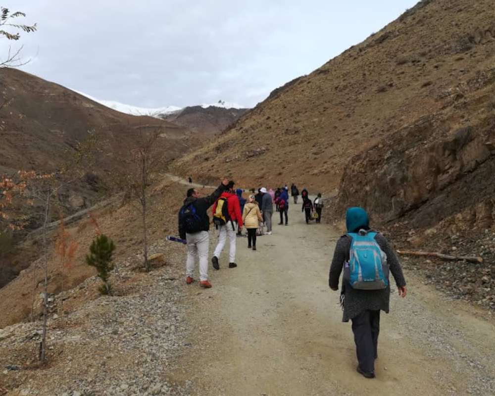 افرادی در حال کوهنوردی به سمت روستای سنگان