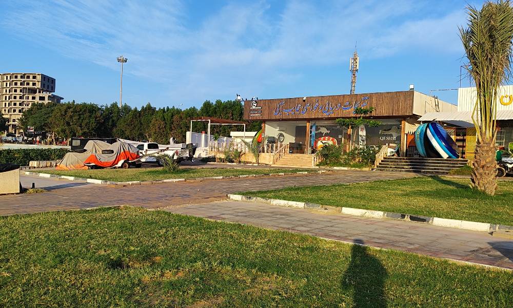 سردر سازمان تفریحات آبی قشم زیر آسمان آبی با فضای سبز جلوی آن
