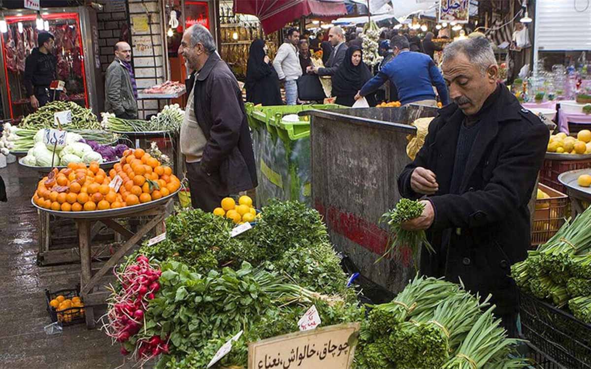 مردی در حال سبزی فروختن در بازار بزرگ رشت