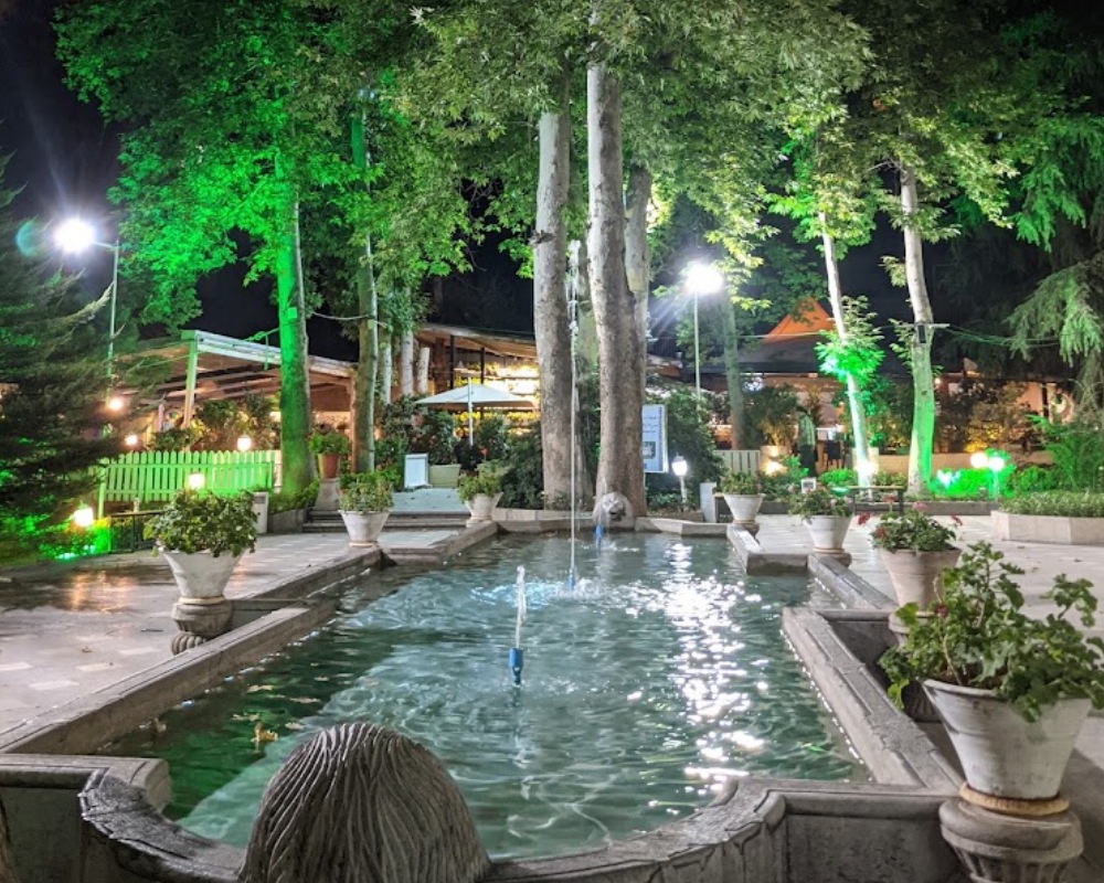 نمایی از حیاط موزه زمان در شب و نورپردازی سبز رنگ آن