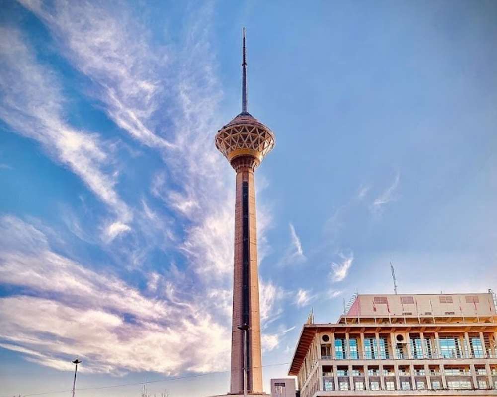 نمایی از برج میلاد با پس زمینه آسمان نیمه ابری آبی