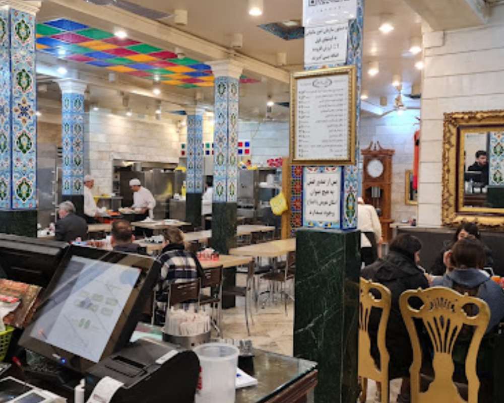نمایی از فضای داخلی رستوران شرف‌الاسلامی با مشتریانی که پشت میز نشستند