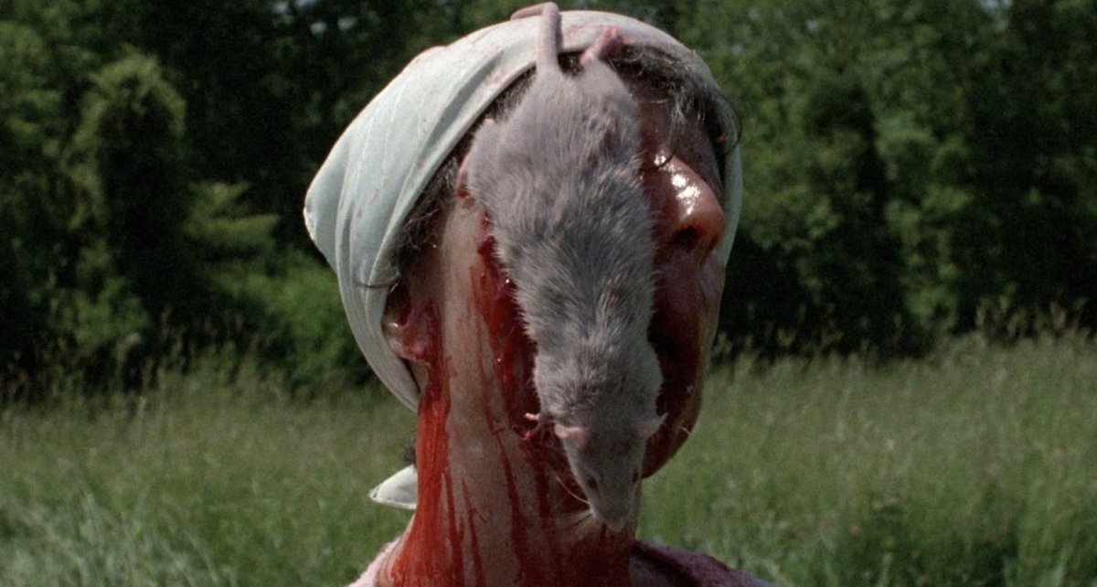 بدن بی‌جان زنی که بر روی مجموعه‌ای از میخ‌های چوبی کوتاه که از تخته‌ای بیرون زده‌اند، در چمن‌ها افتاده است در فیلم Beware! Children at Play