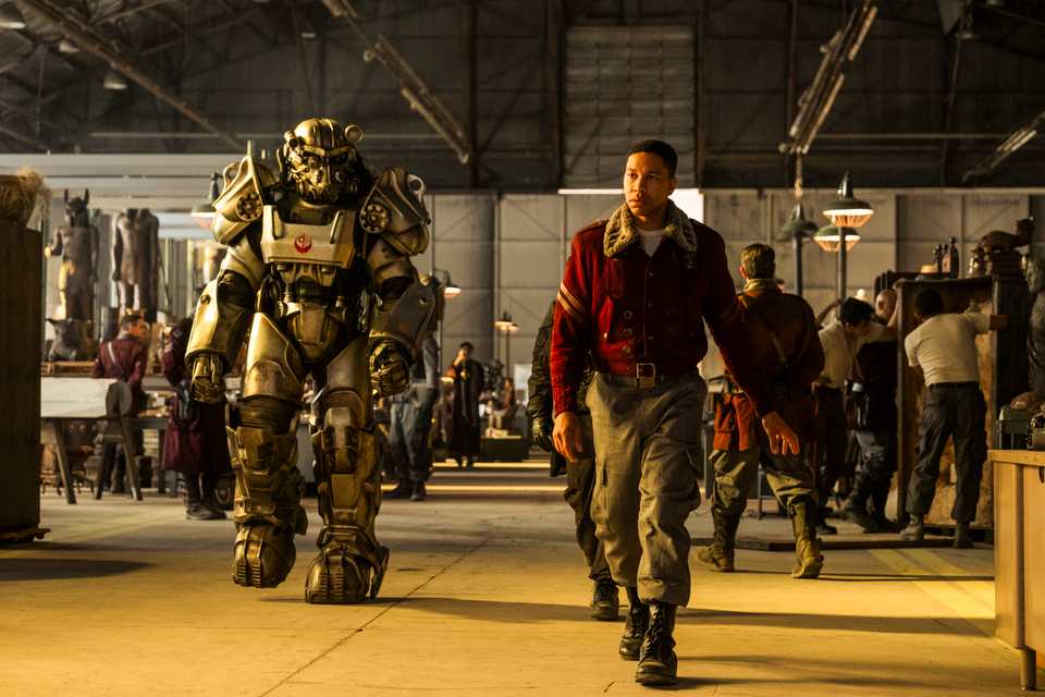 سه شخصیت در لباسهای آبی و زرد کنار هم ایستادهاند. تصویر از فصل دوم Fallout در Prime Video.
