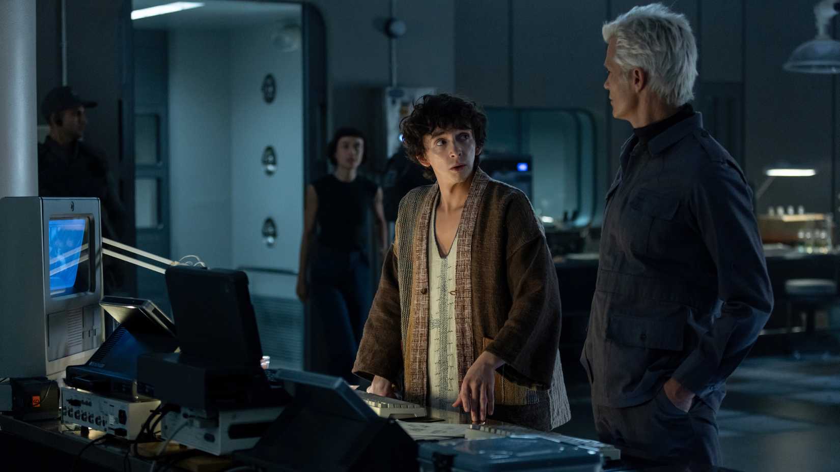 پسر کاوالیر با دانشمند مصنوعی کیرش صحبت می‌کند در حالی که وندی، یک هیبرید، از دور به آنها نزدیک می‌شود.