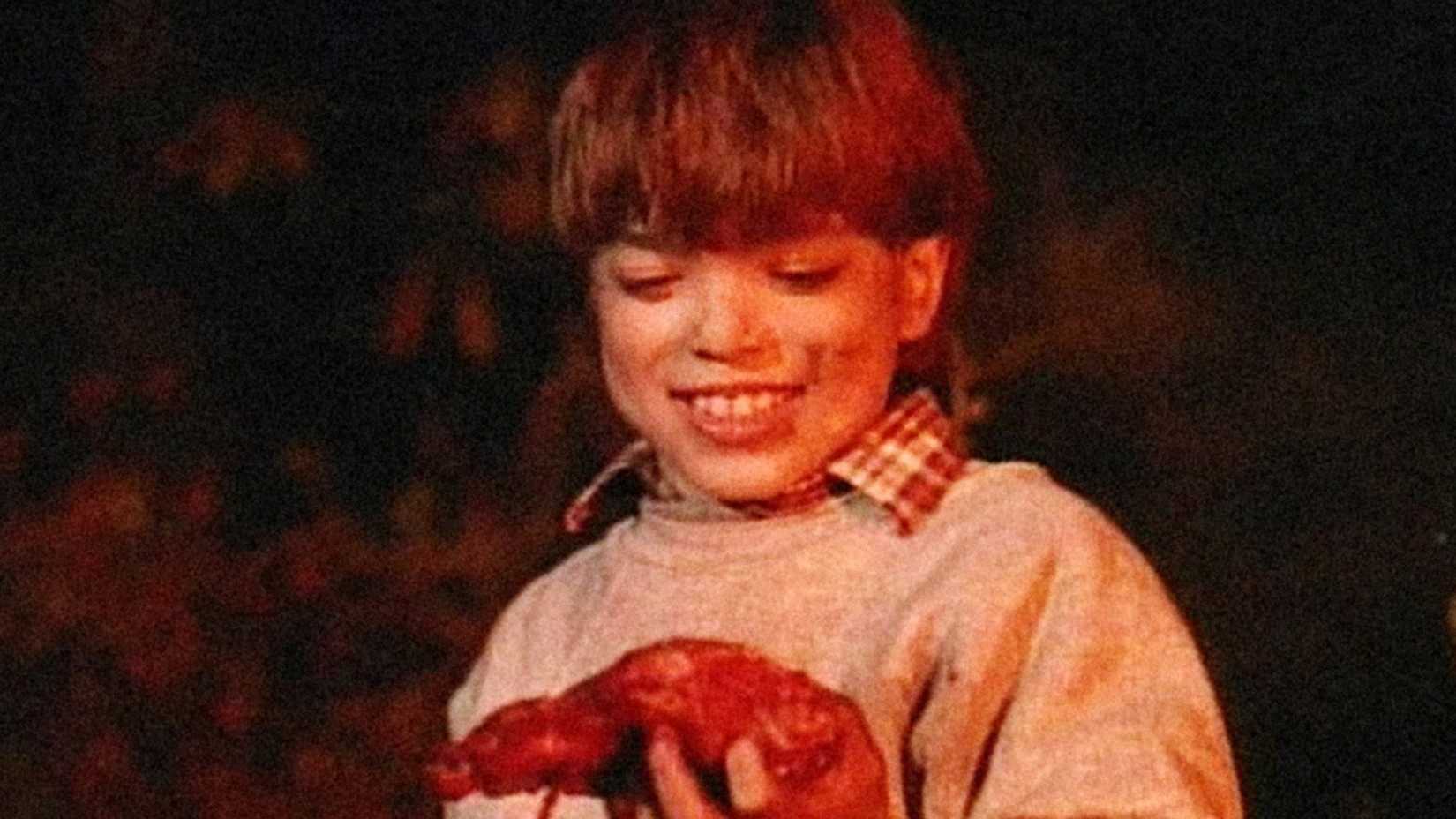 صحنه‌ای از Beware! Children at Play، با یک جسد خون‌آلود که به صورت نشسته قرار دارد و یک موش زنده روی صورتش آویزان است